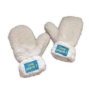 Flauschige cremefarbene Fäustlinge für Damen mit blauem Love Yourself Aufnäher