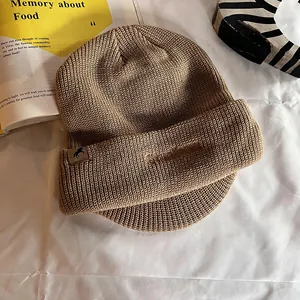 Gros plan détaillé sur casquette en maille kaki avec patch en cuir et broderie hiver