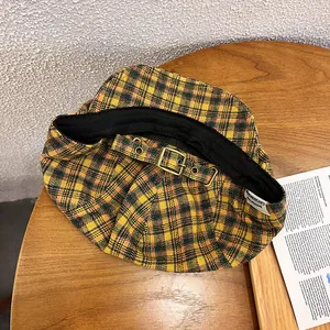 Detail of adjustable metal buckle and vintage checkered fabric on the retro beret hat