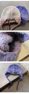 Detail of plush boucle knit aviator hat showing fuzzy texture and earflap strings