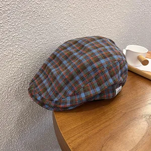 Vintage checkered flat cap with retro plaid pattern on a wooden table setup