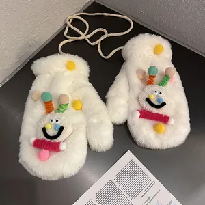 Detail of plush winter mittens with colorful pom-poms and a cute cartoon smiley face