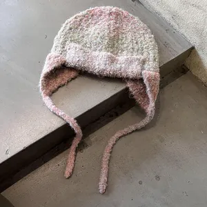 Detail of multi-color mixed yarn knit earflap hat with soft mohair texture and long ties