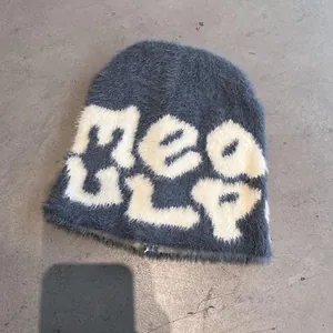 Close-up of blue-grey plush beanie featuring soft mohair texture and white knit lettering