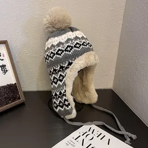 Détail de la doublure en peluche beige épaisse du bonnet en maille ethnique pour l'hiver