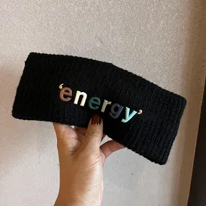 Détail du large bandeau en tricot noir avec lettres colorées energy en caoutchouc 3D