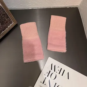 Detail of pink knitted fingerless gloves showing plush faux fur texture and ribbed cuff