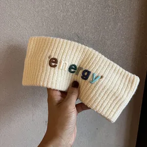 Détail du bandeau en maille crème avec lettres colorées energy en relief 3D