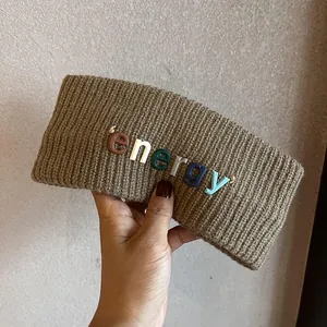 Gros plan du bandeau en maille marron avec lettres 3D colorées energy et texture laine