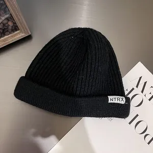 Classic black ribbed knit beanie with NTRX woven label for winter warmth and street style