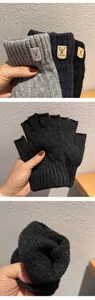 Detail view of thickened thermal lining and deer emblem on knitted fingerless gloves