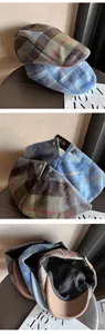 Detail view of vintage plaid ivy cap showing metal buckle and warm thick lining
