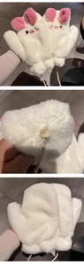 Dettaglio dei guanti in peluche a forma di maialino con orecchie rosa e cordino al collo