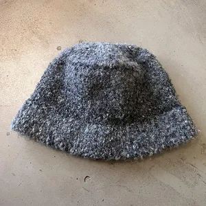 Textured dark grey knit bucket hat with thick gradient yarn and a soft minimalist look