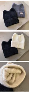 Detail der weichen Strickstruktur und Katzenohren an Wintermützen in verschiedenen Farben