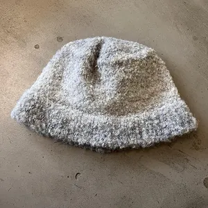 Detailed macro view of the grey textured boucle wool knit on this winter bucket hat