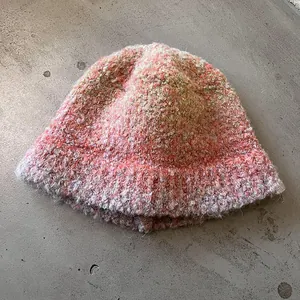 Close-up of fuzzy bouclé knit fabric with pink and orange gradient yarn texture