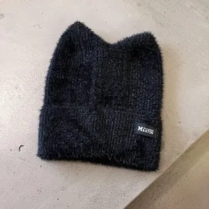 Detail der schwarzen Katzenohr-Beanie mit weichem Kunstkaninchenfell und Markenetikett
