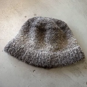 Detailed top view of mixed grey knit fisherman hat featuring textured curly yarn fabric