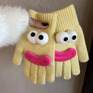 Detail of yellow knit glove with 3D cartoon monster eyes and funny pink plush lips