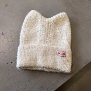 Detailaufnahme der cremefarbenen Katzenohr-Strickmütze mit weicher Mohair-Textur