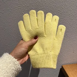 Detail von hellgelben Strickhandschuhen mit gerippten Bündchen und offenen Fingerspitzen
