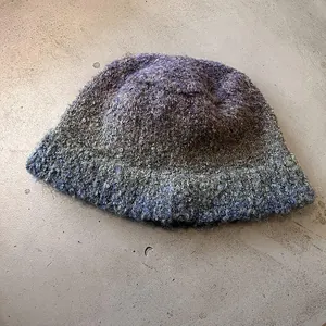 Close-up of thick multi-color knit fisherman hat with purple and blue wool texture