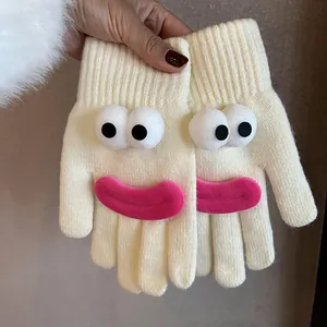 Detail of cream knitted gloves with 3D cartoon big eyes and pink lip decorations