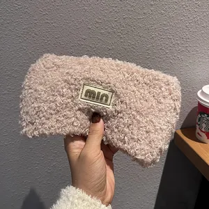 Close-up of soft beige teddy velvet headband featuring a woven MIN label patch