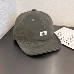 Detailed close-up of dark grey canvas workwear cap with white mountain graphic patch
