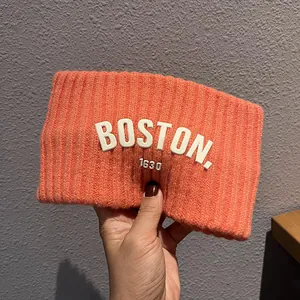 Gros plan sur le bandeau en tricot orange avec broderie BOSTON 1630