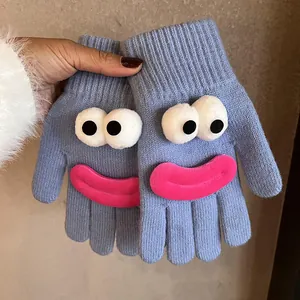 Detail of blue knitted gloves featuring cartoon funny face with big 3D eyes and pink lips