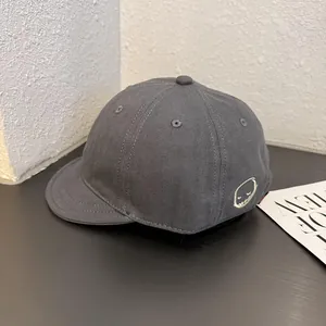 Detail shot of grey herringbone short brim baseball cap with devil face embroidery