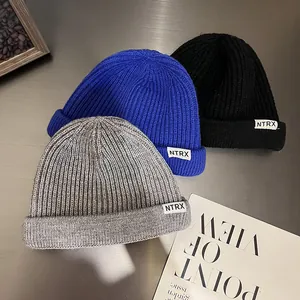 Solid color knit beanies in grey, blue, and black with NTRX logo tag for autumn and winter