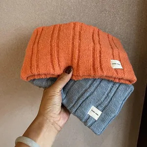 Knitted beanie hat in orange and blue with Cara Park letter patch and striped texture