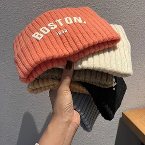 Cinq bonnets en tricot assortis avec lettres Boston 1630 en couleurs douces pour l'hiver