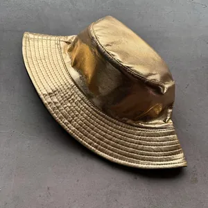 Detailansicht der glänzenden goldenen Metallic-Oberfläche und der Nähte am Fischerhut