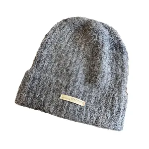 Bonnet en tricot gris foncé pour femme avec texture duveteuse et écusson rectangulaire
