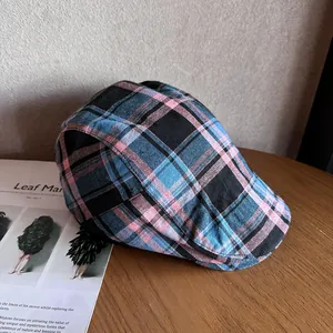 Gros plan d'une casquette rétro à carreaux sur table en bois avec magazine