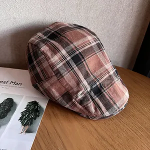 Détail de la casquette à carreaux vintage posée sur une table en bois rustique