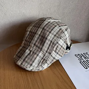 Close-up of vintage khaki plaid fabric texture and pattern on the flat cap peak