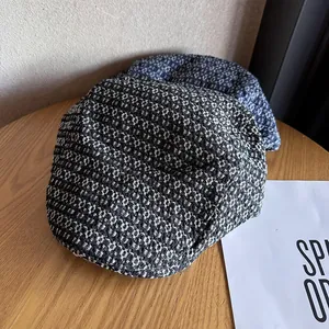 Classic newsboy caps in black and blue tweed, presented on a wooden table in a side view