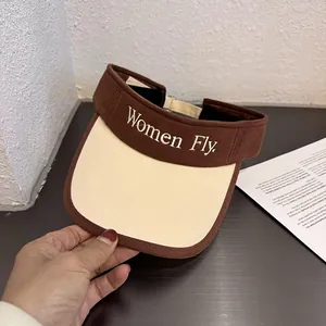 Detailed view of the canvas visor hat featuring embroidered Women Fly letters and brown trim