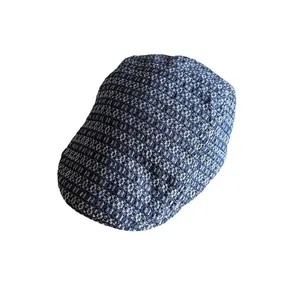 Navy and beige jacquard flat cap with retro woven texture from a high angle view