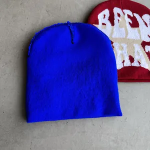 Flachbild-Detail der Strickmützen in Blau und Rot mit weißen Stern- und Buchstabenmustern
