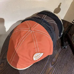Vintage canvas newsboy hat with contrast stitching and retro embroidered patches