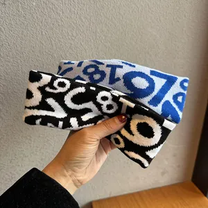 Elastic knitted sports headband with numerical jacquard pattern in black and blue