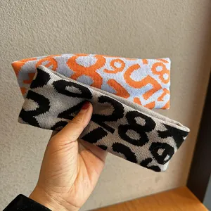 Macro detail of knitted sports headbands showing two-tone jacquard number patterns