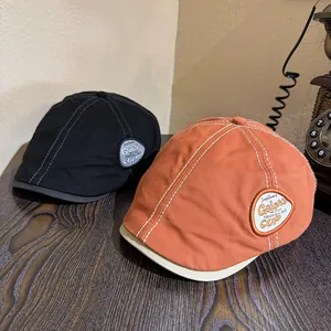 Detailed close-up of retro newsboy caps with embroidered badges and vintage textures