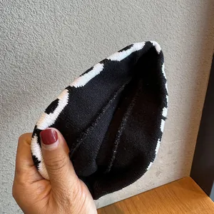 Detail shot of black and white knitted headband showing thick texture and inner stitching